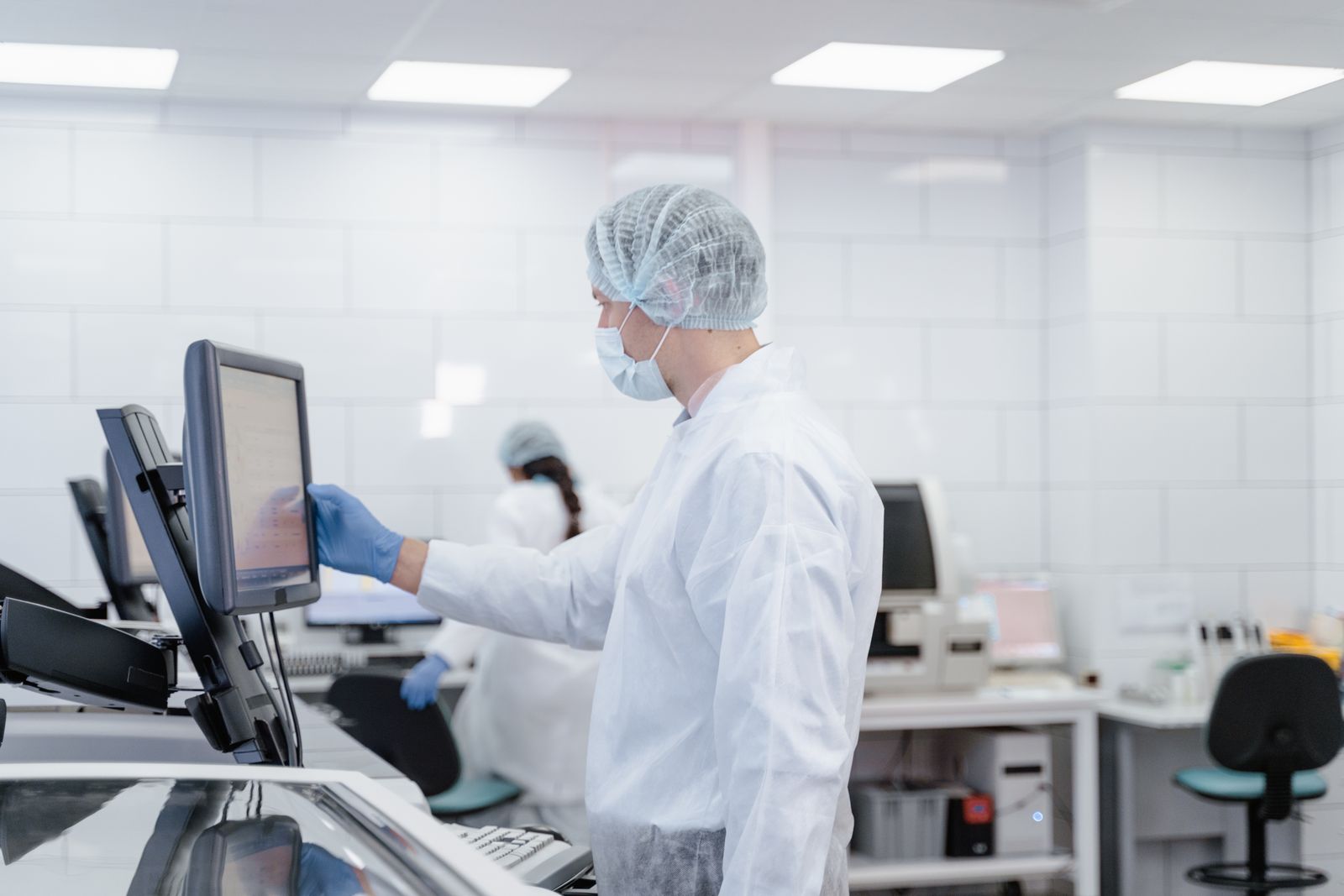 A laboratory specialist using the touchscreen on an analytical instrument.